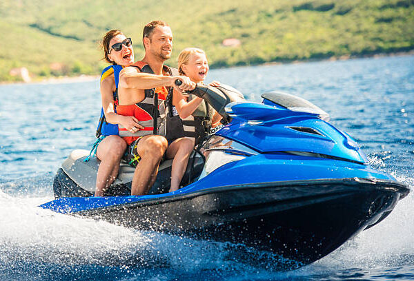 Family having fun riding a water scooter on the sea.